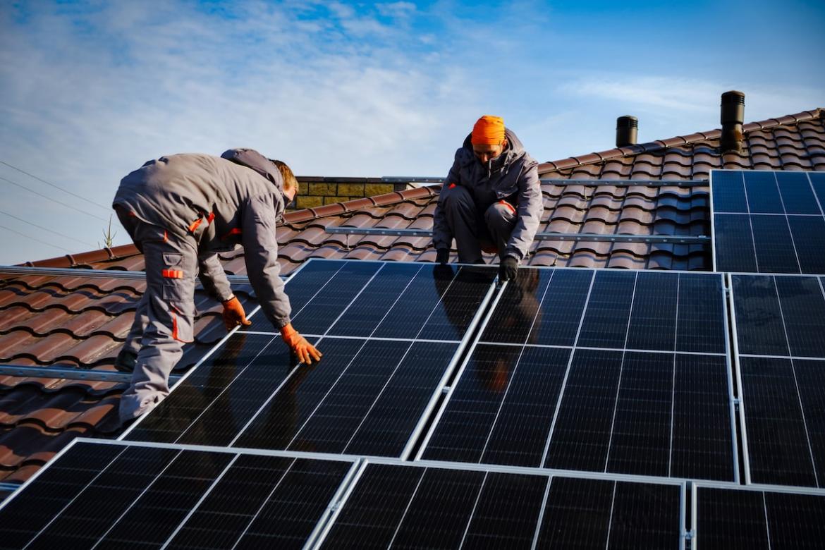 Builders installing rooftop solar panels