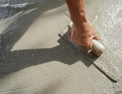 Person spreading cement on foundation