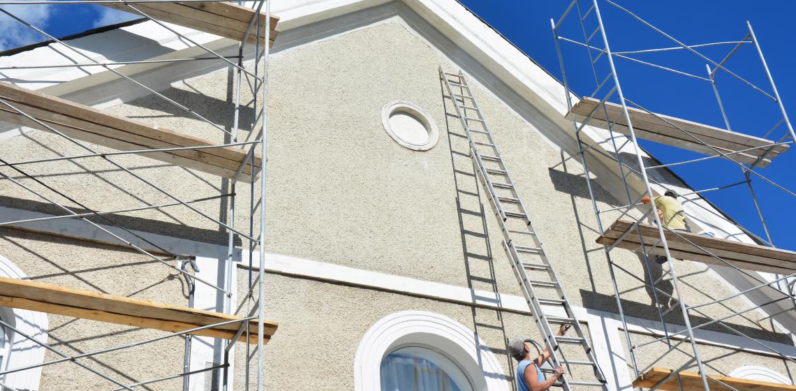 House builder working on stucco exterior