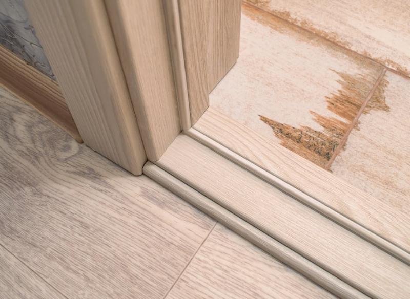 Moisture damaged hardwood floor inside door frame